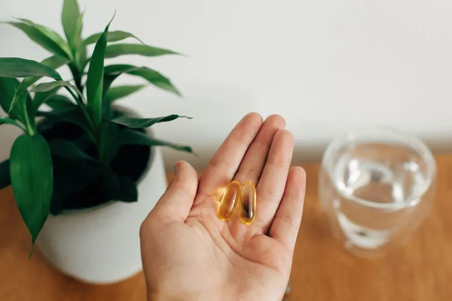 hand holding omega 3 supplements